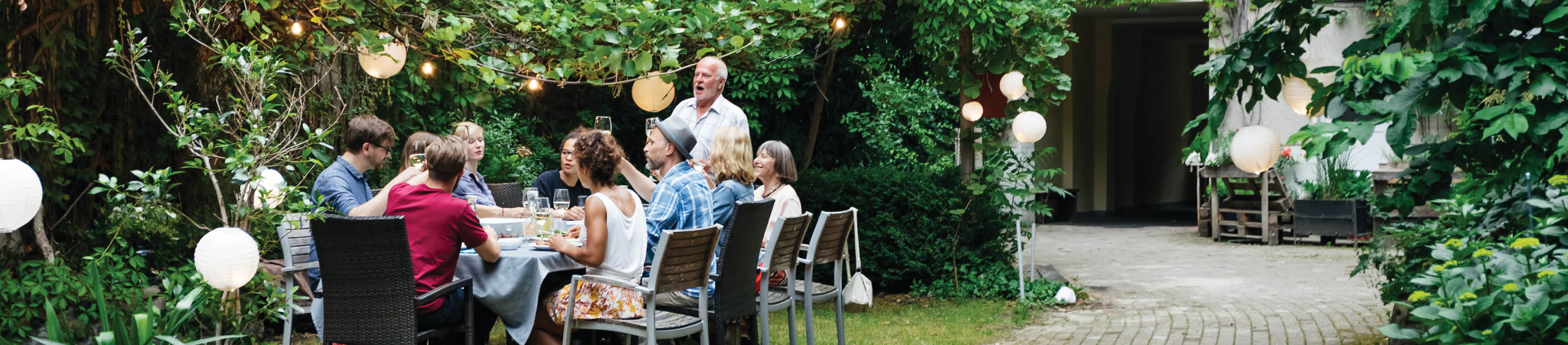 Image of large group of people dining outdoors.