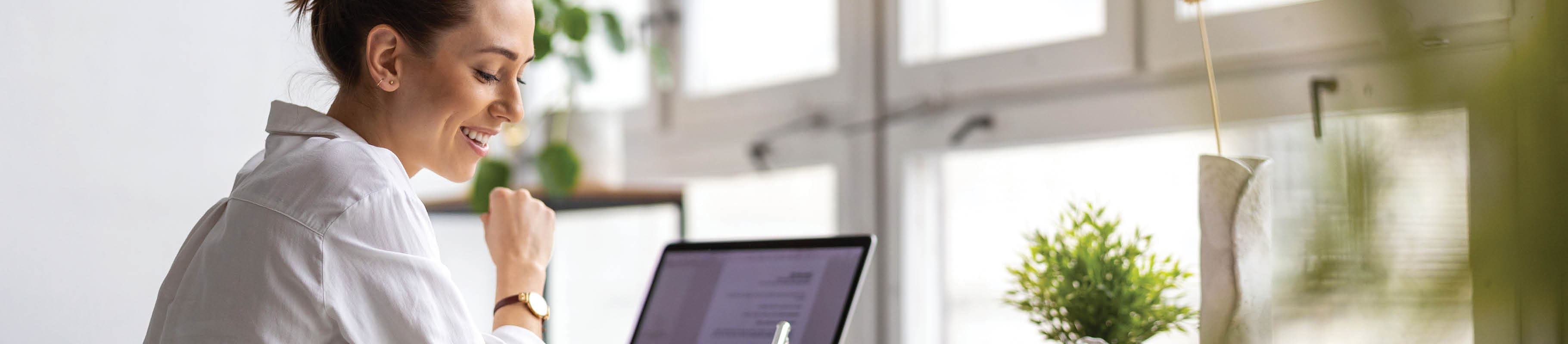 Image of office table filled with pens, computers, paperwork and hands. 
