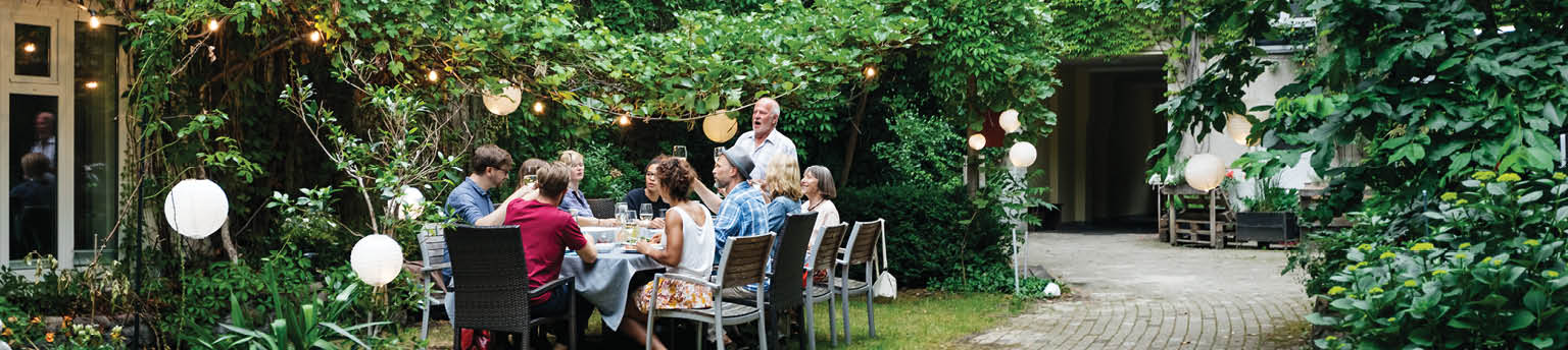 Image of large group of people dining outdoors.