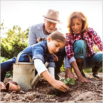 Image of older couple gardening with young girl.