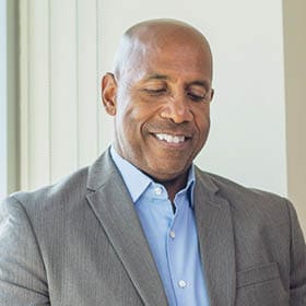 Image of older man smiling while on a tablet.