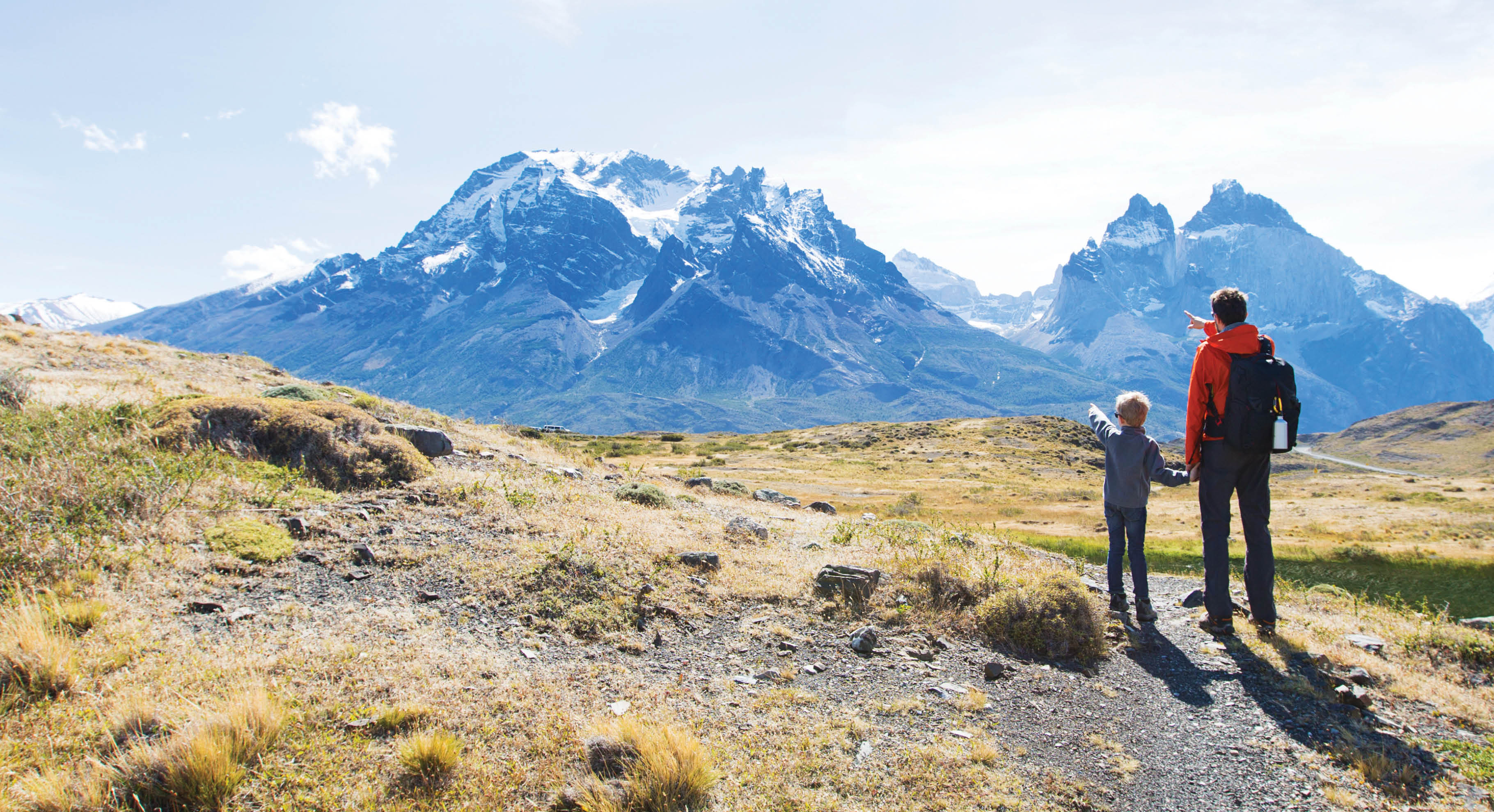 Father and son hiking and pointing at distant mountains