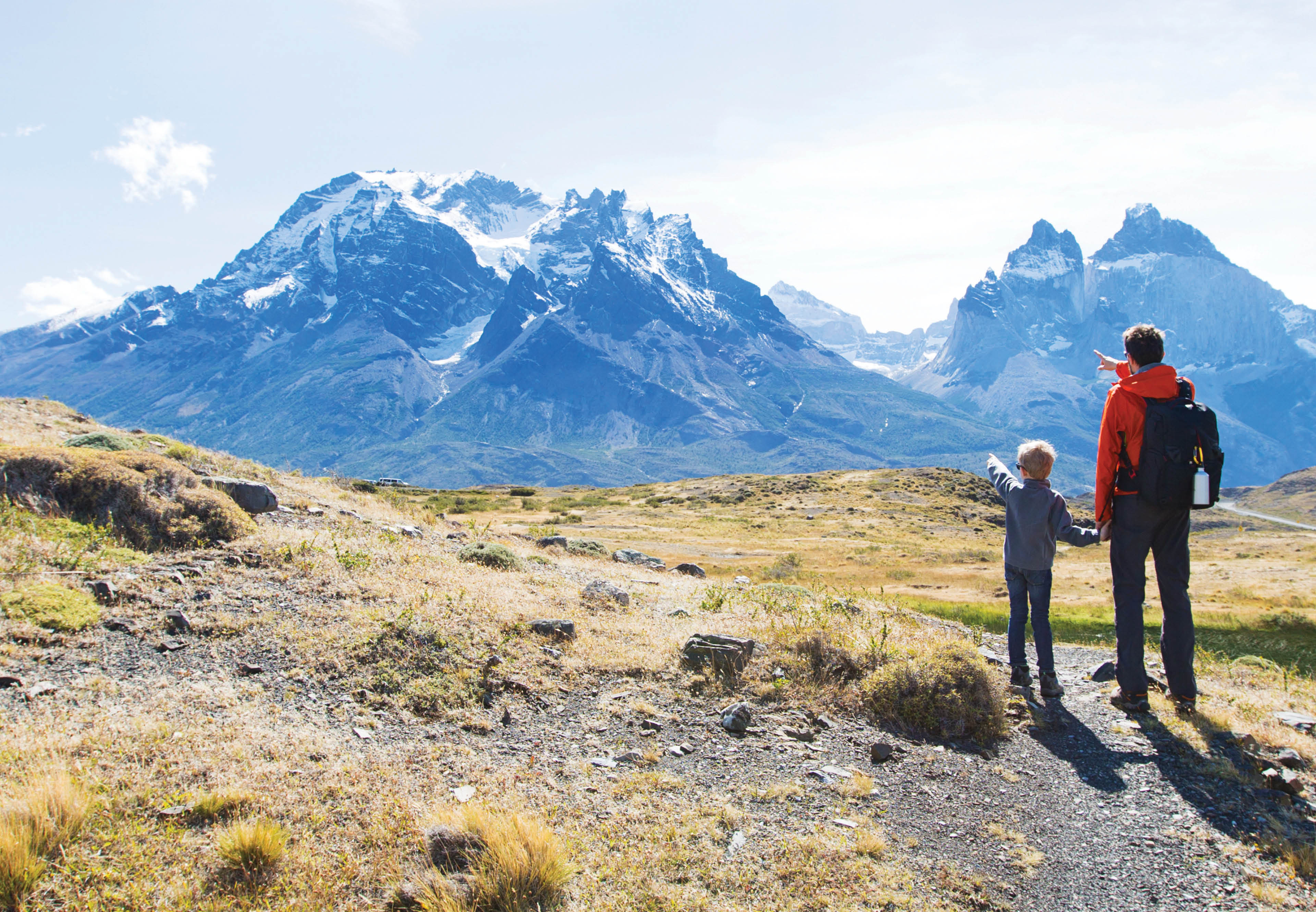 Father and son hiking and pointing at distant mountains