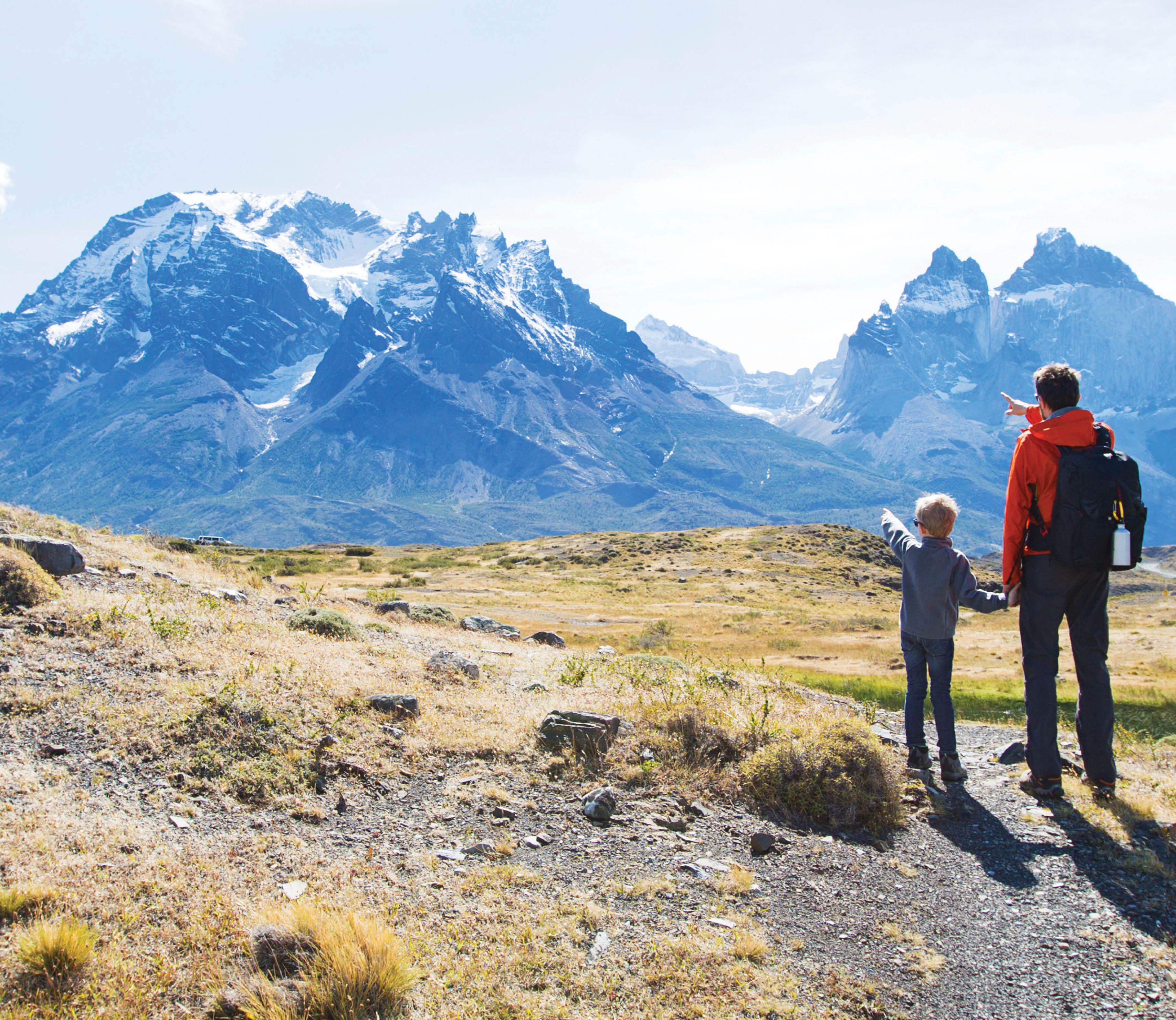 Father and son hiking and pointing at distant mountains