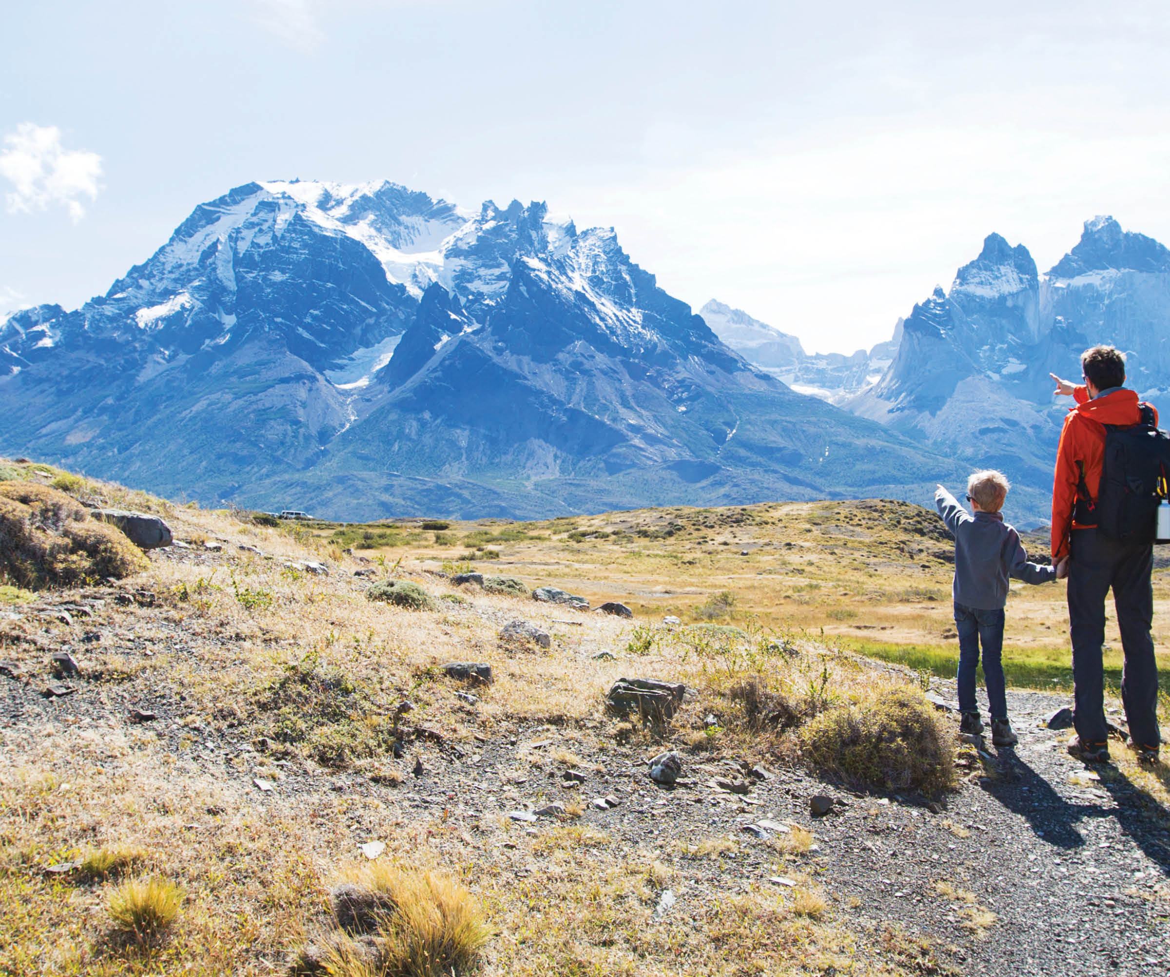 Father and son hiking and pointing at distant mountains