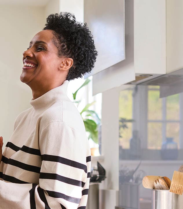 woman holding smart phone in her kitchen