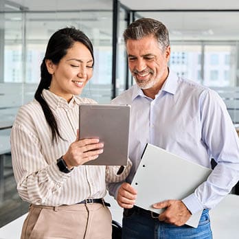 businessman and businesswoman looking at an electronic tablet