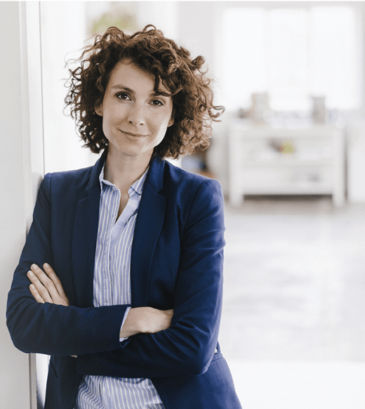 businesswoman leaning against wall with arm crossed